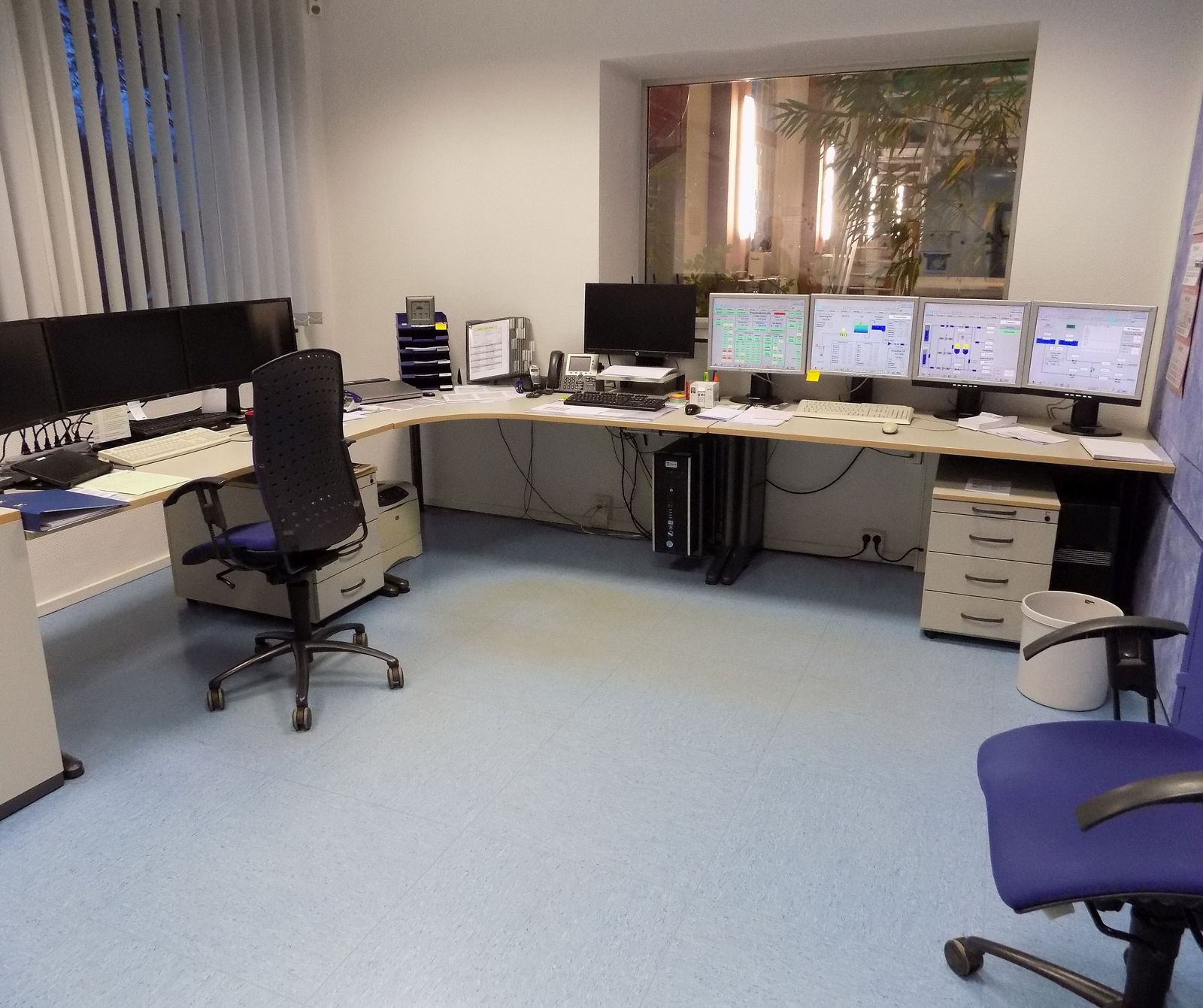 Salle de supervision d’une usine d’eau : postes de travail et écrans affichant des synoptiques.